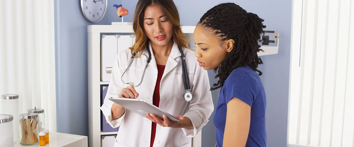 Healthcare provider discussing non-surgical treatment options for sciatica with a patient experiencing lower back and leg pain.